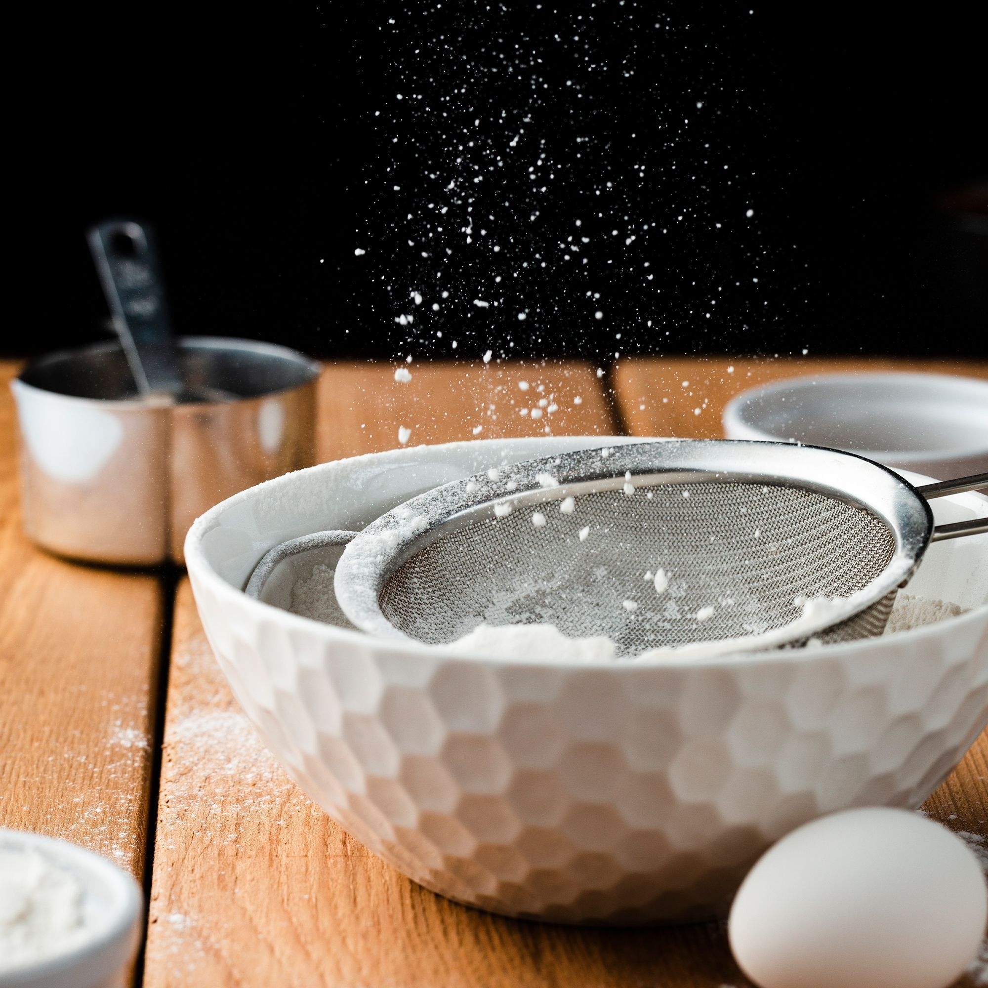 Fine kitchen sieve in bowl with flour